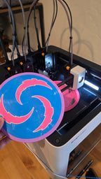 Pink and blue Cotton Candy CC-001 prototype held in front of Luke's 3D printer
